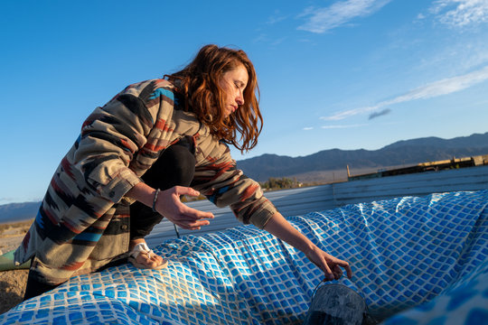 A woman collects rain water while off grid living in a remote desert near Joshua Tree, California