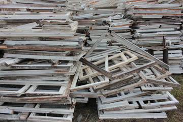 Heap of construction debris from old wooden window frames with glass outdoors. Reusable waste from...