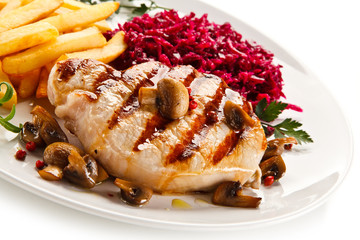 Grilled steak, French fries and vegetables on white background