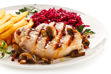 Grilled steak, French fries and vegetables on white background