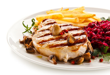 Grilled steak, French fries and vegetables on white background