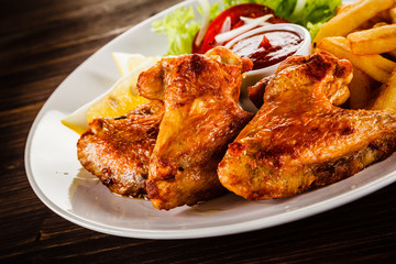 Fried chicken wings with french fries and vegetable salad