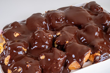  Chocolate Profiterole. Sweet dessert on white plate. Homemade profiteroles with cream and chocolate sauce.