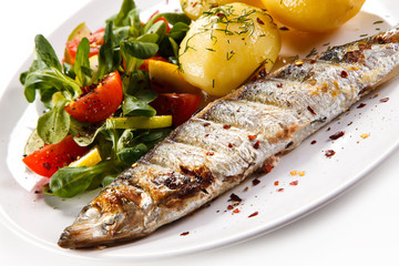 Fish dish - grilled herring with vegetables on white background