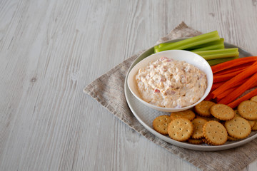Homemade Pimento Cheese Dip with carrots, celery and crackers, side view. Copy space.