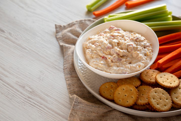 Homemade Pimento Cheese Dip with carrots, celery and crackers, side view. Copy space.