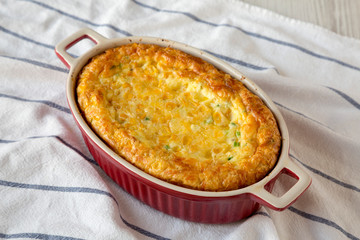 Homemade Cheese Corn Pudding Casserole on cloth, side view. Close-up.