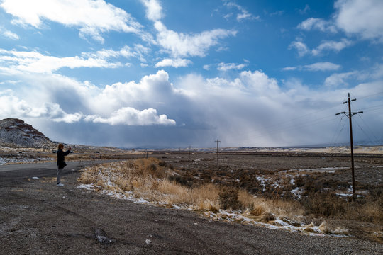 A traveler takes a selfie as storm clouds approach a rural highway