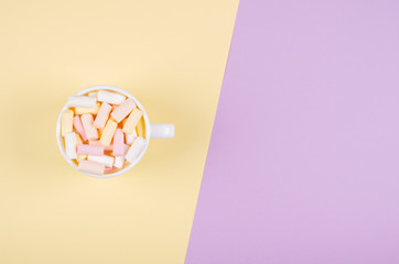 Colored marshmallow composition on purple background. Flat lay.