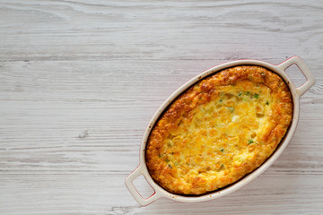 Homemade Cheddar Corn Pudding Casserole on a white wooden background, top view. Flat lay, top view,...