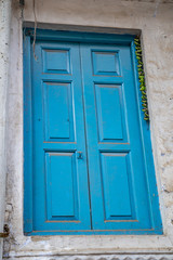 Bright blue door in an alley in Old Delhi India. Green chillies tied on a thread hanging to keep away Alakshmi, or Jyestha