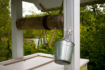 Country well with a bucket on a chain.
