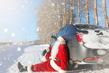 Santa Claus comes with gifts from the outdoor. Santa in a red suit with a beard and wearing glasses is walking along the road to Christmas. Father Christmas brings gifts to children.