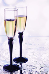 Background with tall glasses for sparkling wines. Champagne and spray in glass glasses. Celebratory drink with reflection.