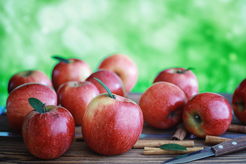 Fresh apples on a wooden board. Harvest of red apples. Fruits and cinnamon on the table.