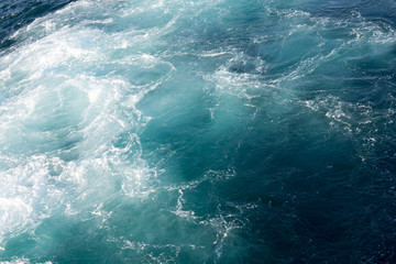 Fototapeta na wymiar white foam in the seething blue sea
