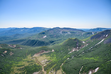 Fototapeta premium Panoramic view of the city Petropavlovsk-Kamchatsky and volcanoes: Koryaksky Volcano, Avacha Volcano, Kozelsky Volcano. Russian Far East, Kamchatka Peninsula.