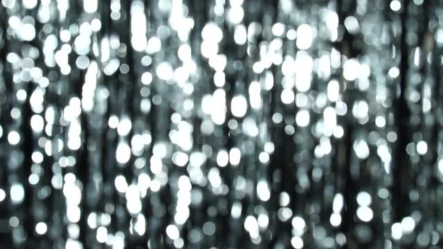 Abstract shiny background with silver defocused bokeh. Beautiful dynamic background in shining lights and sparkling particles. Festive mood. Christmas or holiday theme