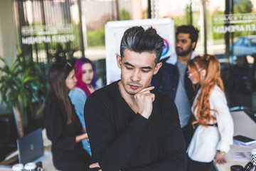 Group of multi ethnic executives discussing during a meeting. Business man and woman sitting around table at office and smiling. A team of young creative designers