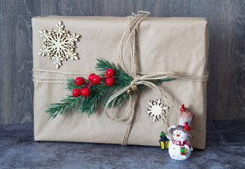 Packed Christmas gift with Christmas tree branch and red berries and Christmas toys