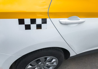 Close up side view of  yellow and white taxi car with checker