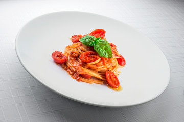 Elegant White round plate with spaghetti tomato and basil