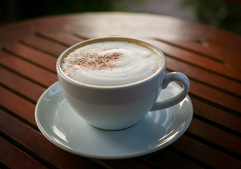 Blurred images of ready-to-drink cappuccino cups placed on a wooden table in the morning as background images and beautiful illustrations
