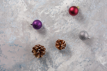 Cedar cones and Christmas balls on a gray background. Decoration for New Year and Christmas.