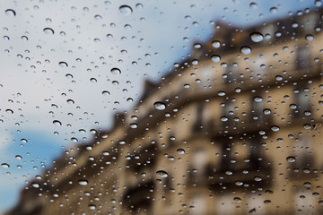 City street seen through rain drops on the car window.