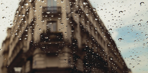 City street seen through rain drops on the car window.