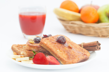 A plate of french toast with bananas, strawberries and jam. Sweet breakfast with french toast and fruit.