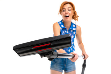 European girl with a vacuum cleaner in hands on a white background