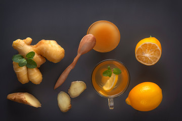Ginger tea with lemon, honey and mint on a gray wooden table. Top view