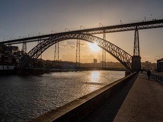 Porto, Portugal. 15 November 2019. Autumn sun setting over Douro River behind Ponte Luis I.
