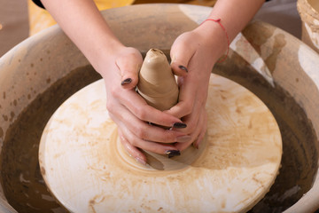 Close-up of potter turning a pot on a potter, hands