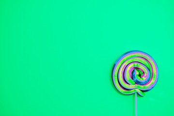 Colorful lollipop swirl on stick. Striped spiral multicolored candy. Copy space. Top view.