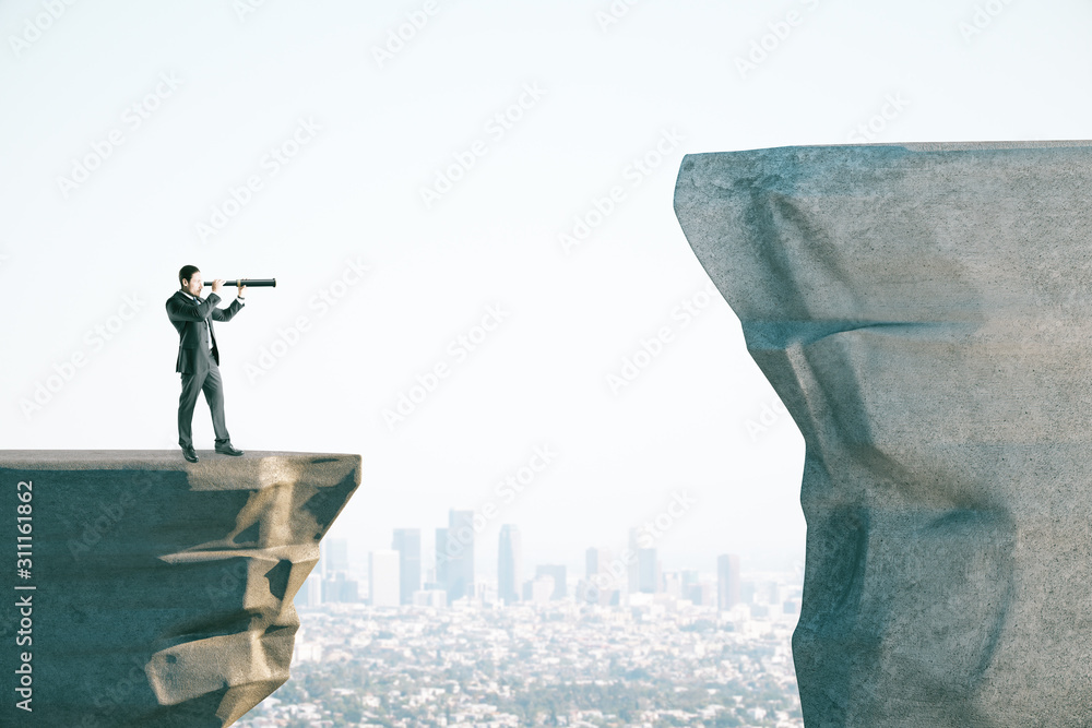 Poster young businessman on cliff looking into distance