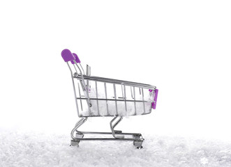 snow on shopping trolley, on white background, New Year and Christmas buying.