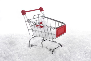 snow on shopping trolley, on white background, New Year and Christmas buying.