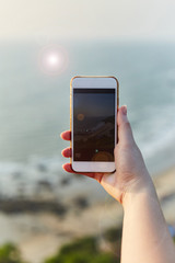 Girl photographs the sunset on the phone