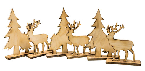 Cut out deer figure made of wood with dark edges and wooden fir trees