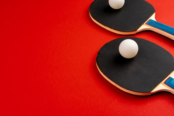 Black ping pong rackets on red background