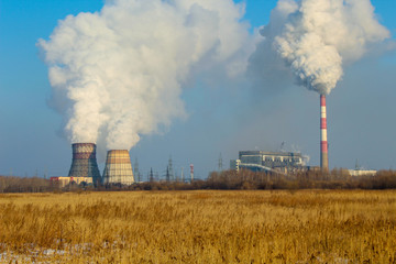 Fototapeta na wymiar Smoking power plant against the blue sky