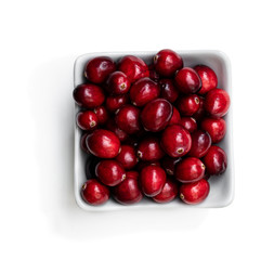 Fresh cranberries in bowl isolated on white. Top view.