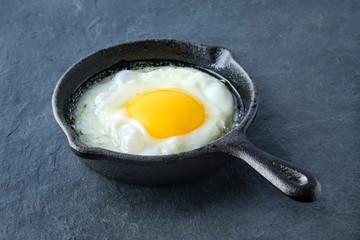 Scrambled egg  in small cast-iron skillet. Making omelet eggs.