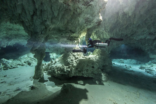 A DPV cave diver swims in the Chan hal cenote (Mexico)