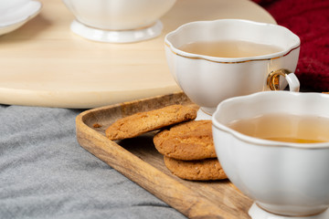 White porcelain cup of tea and oat cookies on a table