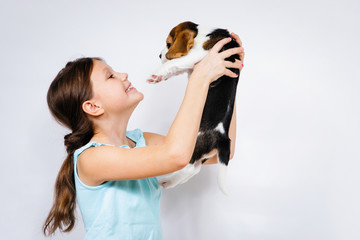 Teen girl holding beagle dog.