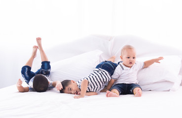 Selective focus twin adorable boys kids happy playing together on bed at home, Asian twin brother and sibling baby cute boy spent time sit together on bed at home, preschool kids boy playing on bed