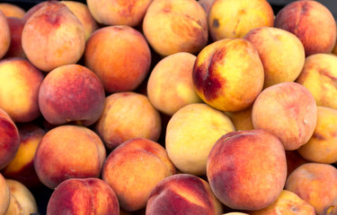 Fototapeta na wymiar a bunch of juicy ripe peaches in an oriental bazaar